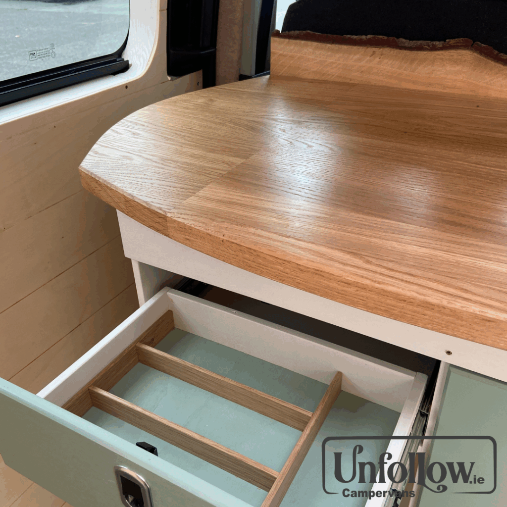 Here at Unfollow we want you to have the same - or even higher- neat living standards and comforts as in your home. An example is that we build purpose made cuttlery drawers into our camper kitchens to reduce clutters and make delicious meals on the road a pleasurable experience. This specific van also features a beautiful Irish Oak countertop. with a live edge Oak splashback..