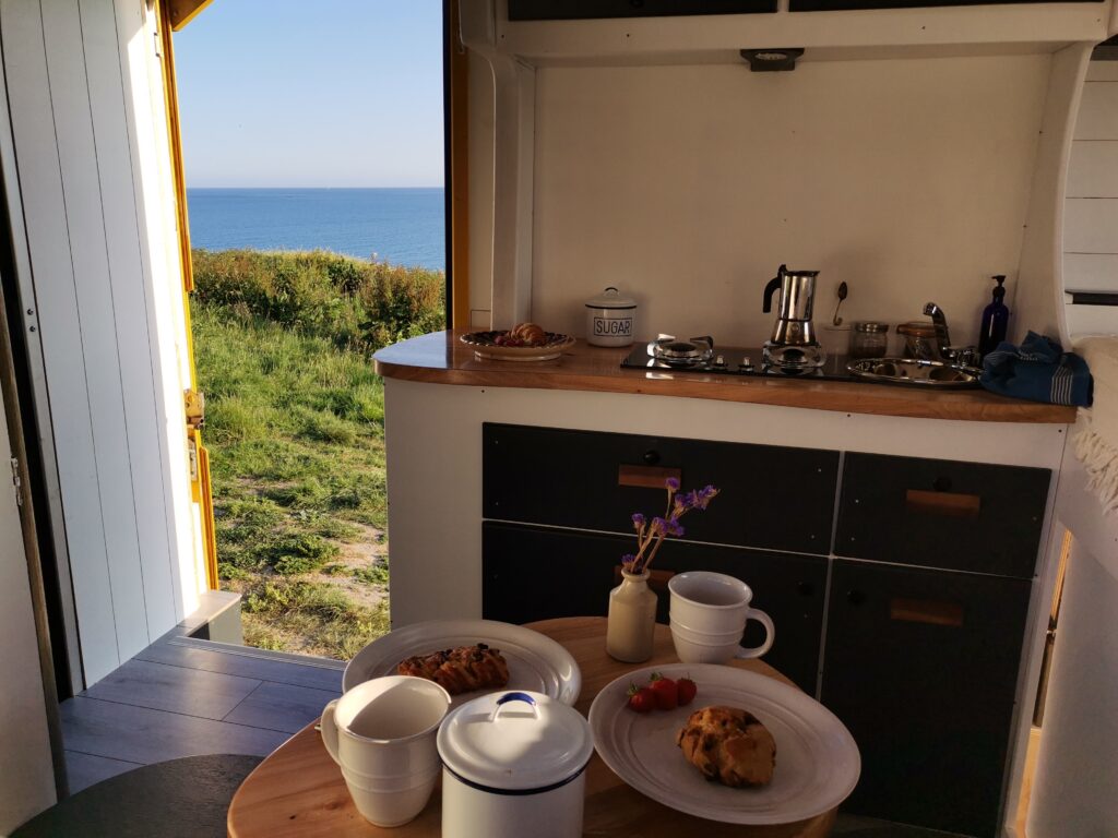 Have a tasty breakfast with a view over the atlantic ocean in a rolling land superyacht from Unfollow Camper Vans.